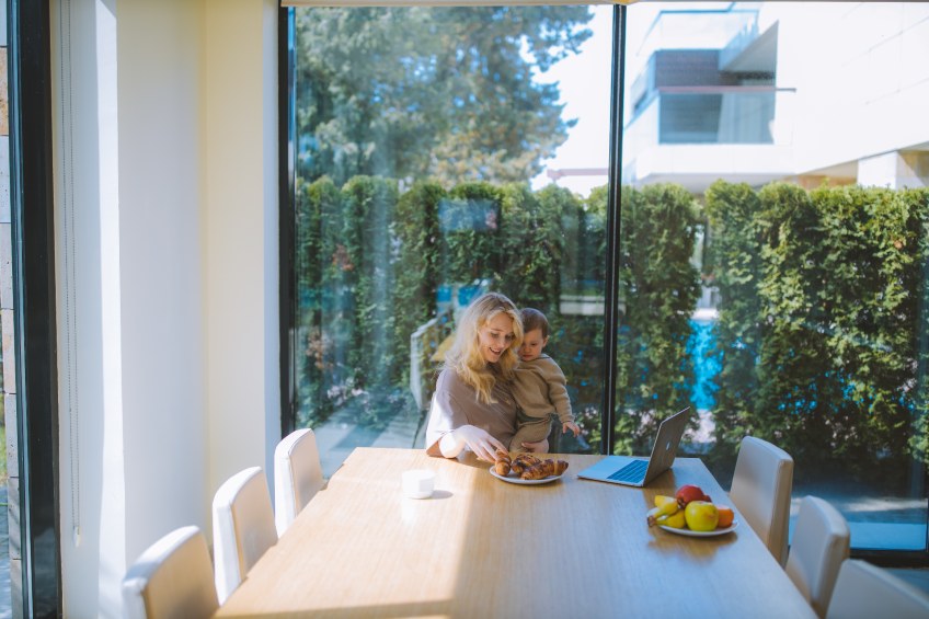 woman holding baby at kitchen table